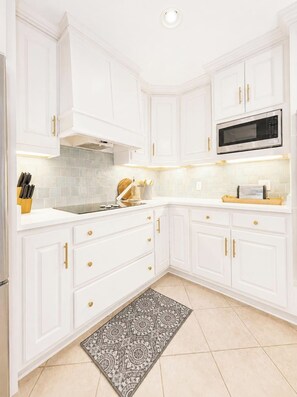 A kitchen with white cabinetry, a microwave, and a patterned rug. - The Park House, 1.8mi to Square, VelvetDitchVillas (Oxford)