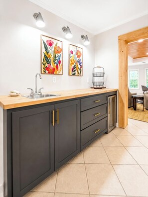 A modern kitchen with a wooden countertop, black cabinets, and two wall-mounted light fixtures. - The Park House, 1.8mi to Square, VelvetDitchVillas (Oxford)