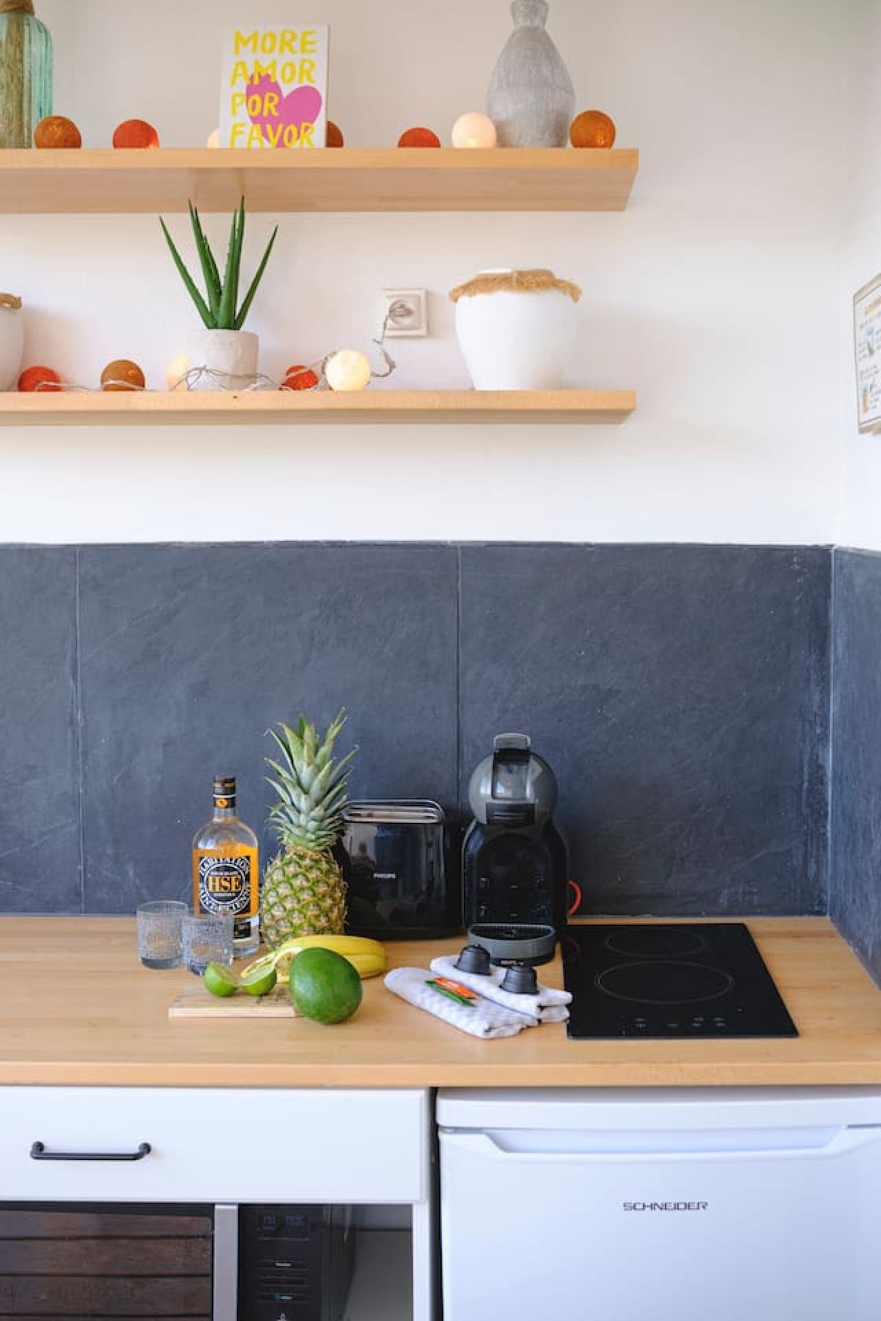 Une cuisine avec un plan de travail en bois, une machine à café, un grille-pain et une bouteille de spiritueux.