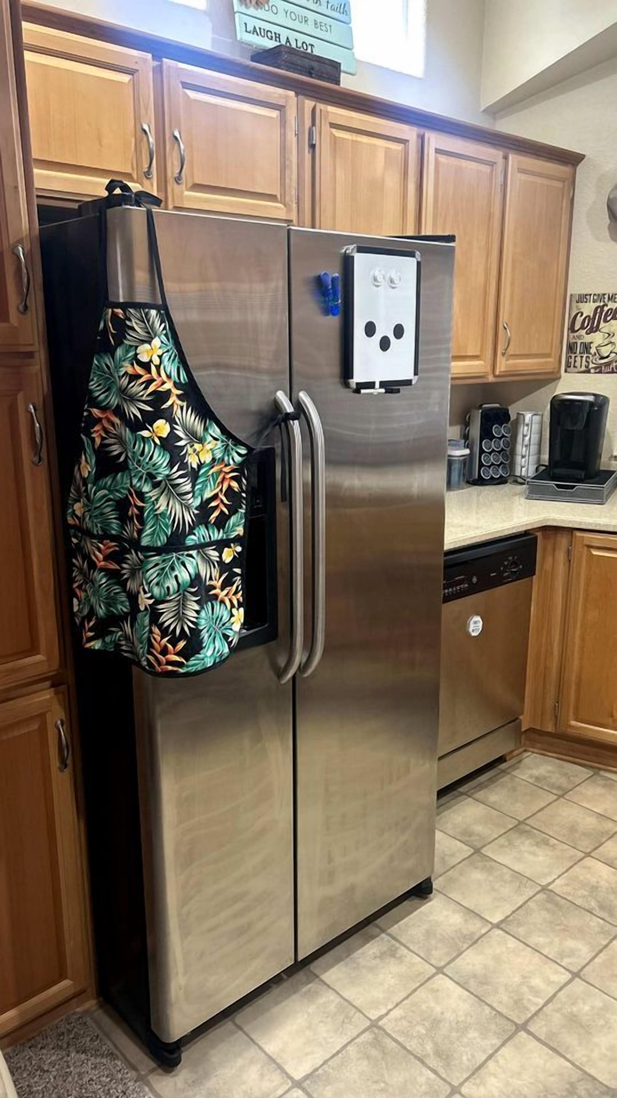 A stainless steel refrigerator with a freezer on top, a microwave, and a coffee maker on the countertop.