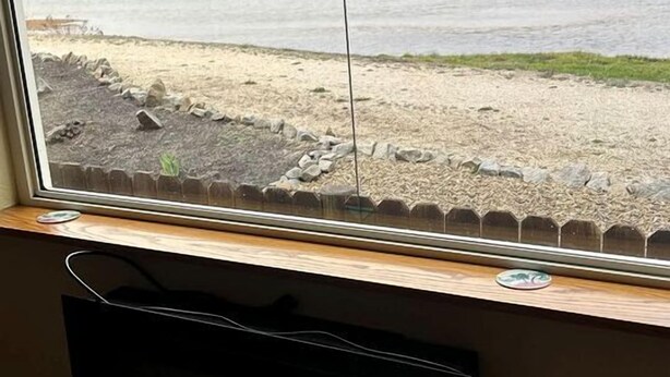 A window with a view of a body of water and a grassy area. - Pet-Friendly Riverfront Getaway with Outdoor Entertaining & Bonus Camper in Cascade, Idaho (Cascade)