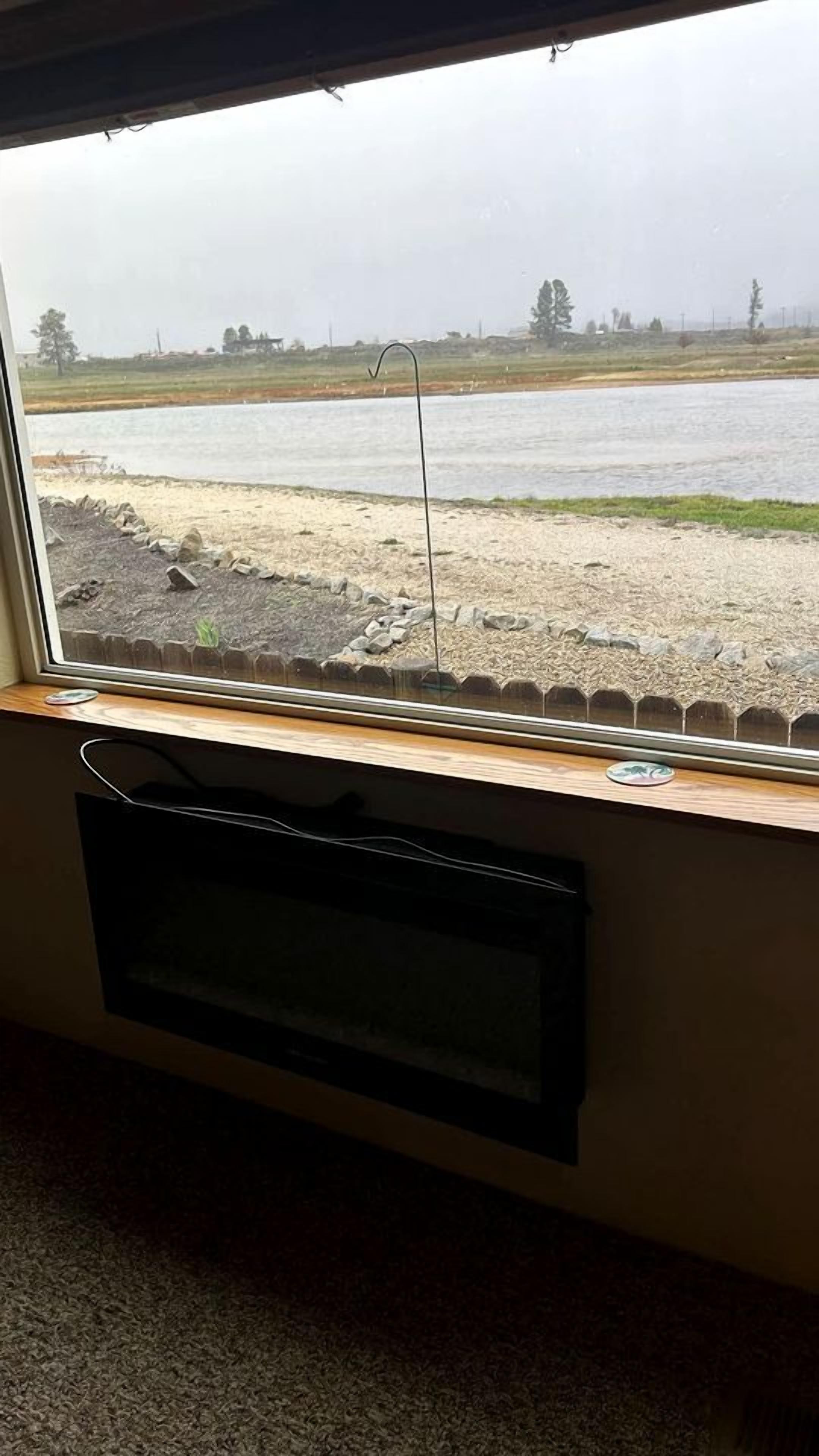 A window with a view of a body of water and a grassy area.