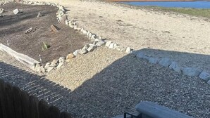 A view of a riverbank with a gravel path and a wooden fence. - Pet-Friendly Riverfront Getaway with Outdoor Entertaining & Bonus Camper in Cascade, Idaho (Cascade)