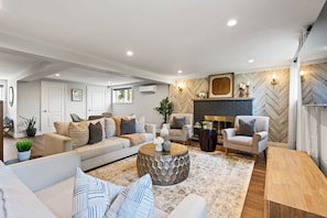 A modern living room with a sofa, armchairs, a coffee table, and a fireplace. - Spruce Valley Farm Retreat (Fort Erie)
