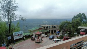 Blick auf eine Stadt mit einem Hotel und Restaurant namens 'Clouds' und einem Schild für das 'Crossroad Roof Top Café'.