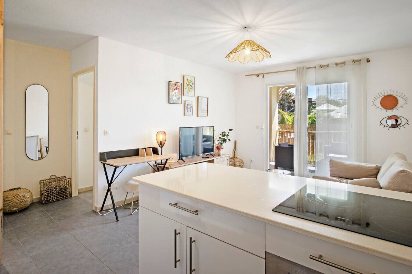 A modern kitchen with a central island, a dining area with a table and chairs, and a living area with a sofa.