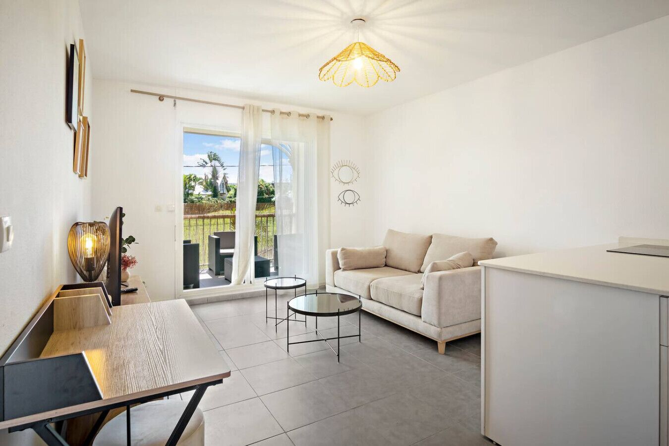 A modern living room with a sofa, a coffee table, and a dining area with a table and chairs.