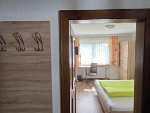 Ein Hotelzimmer mit Bett, Stuhl, Schreibtisch und Kleiderschrank.