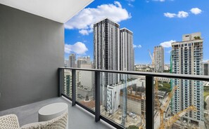 Ein Balkon mit Blick auf die Stadt, ein runder Tisch und ein Stuhl.
