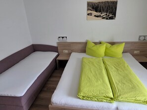A bedroom with a bed, a sofa, and a wall-mounted picture. - Stylishly renovated and panoramic view (Kappl)
