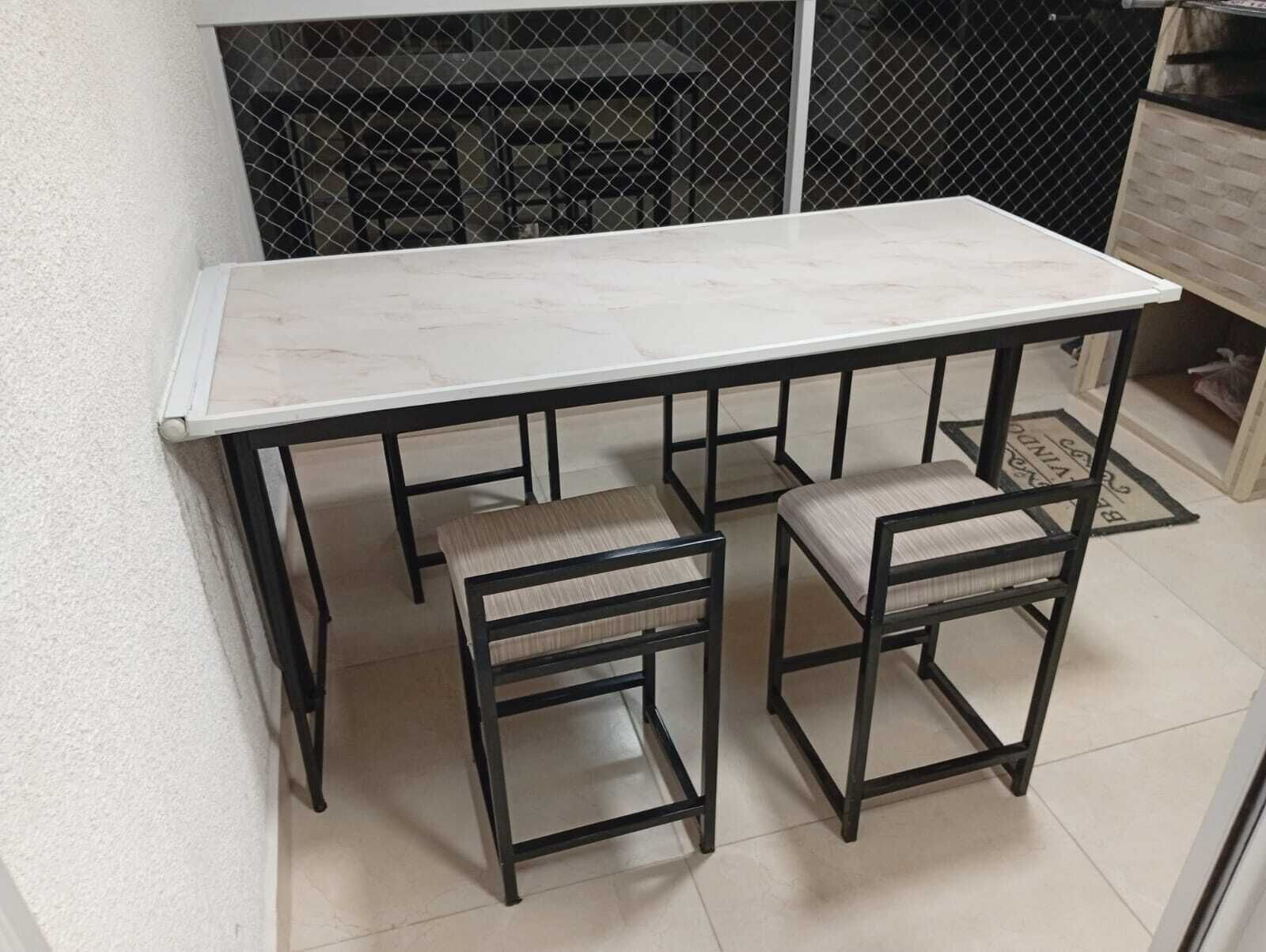 Een witte marmeren tafel met zwarte metalen poten en twee bijpassende stoelen.