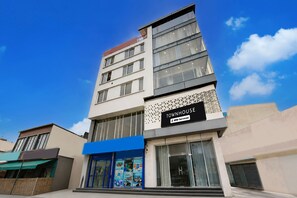 Un edificio de varios pisos con un letrero que indica que cuenta con servicios de OYO.