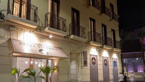 En hotels facade med et skilt, der viser 'REINA VICTORIA', og en portindgang.