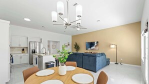 A modern kitchen with white cabinetry, a built-in oven, and a stainless steel refrigerator.