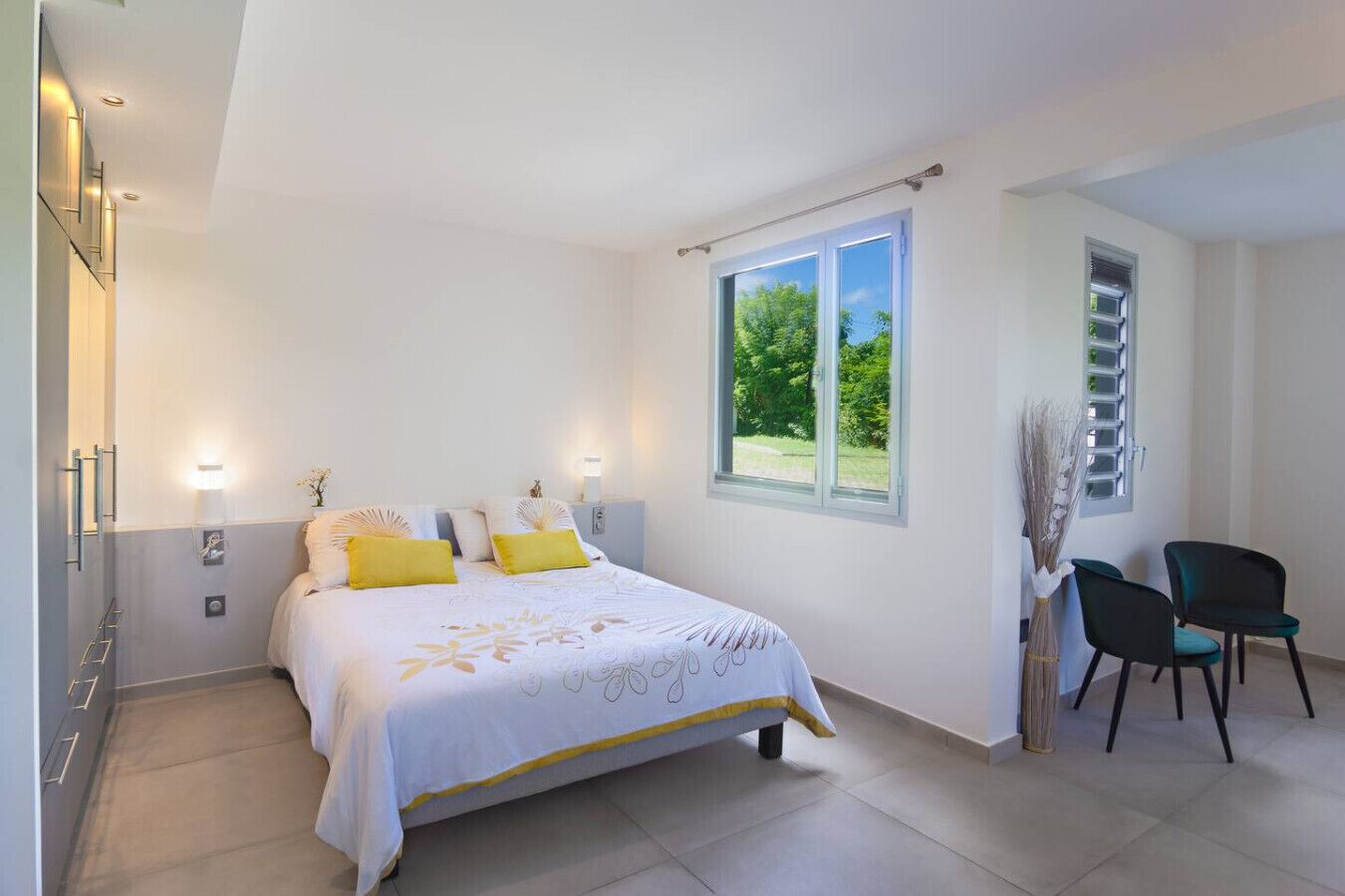 A bedroom with a bed, bedside tables, a window, and a chair.