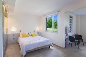 Une chambre à coucher avec un lit, des tables de chevet, une fenêtre et une chaise.