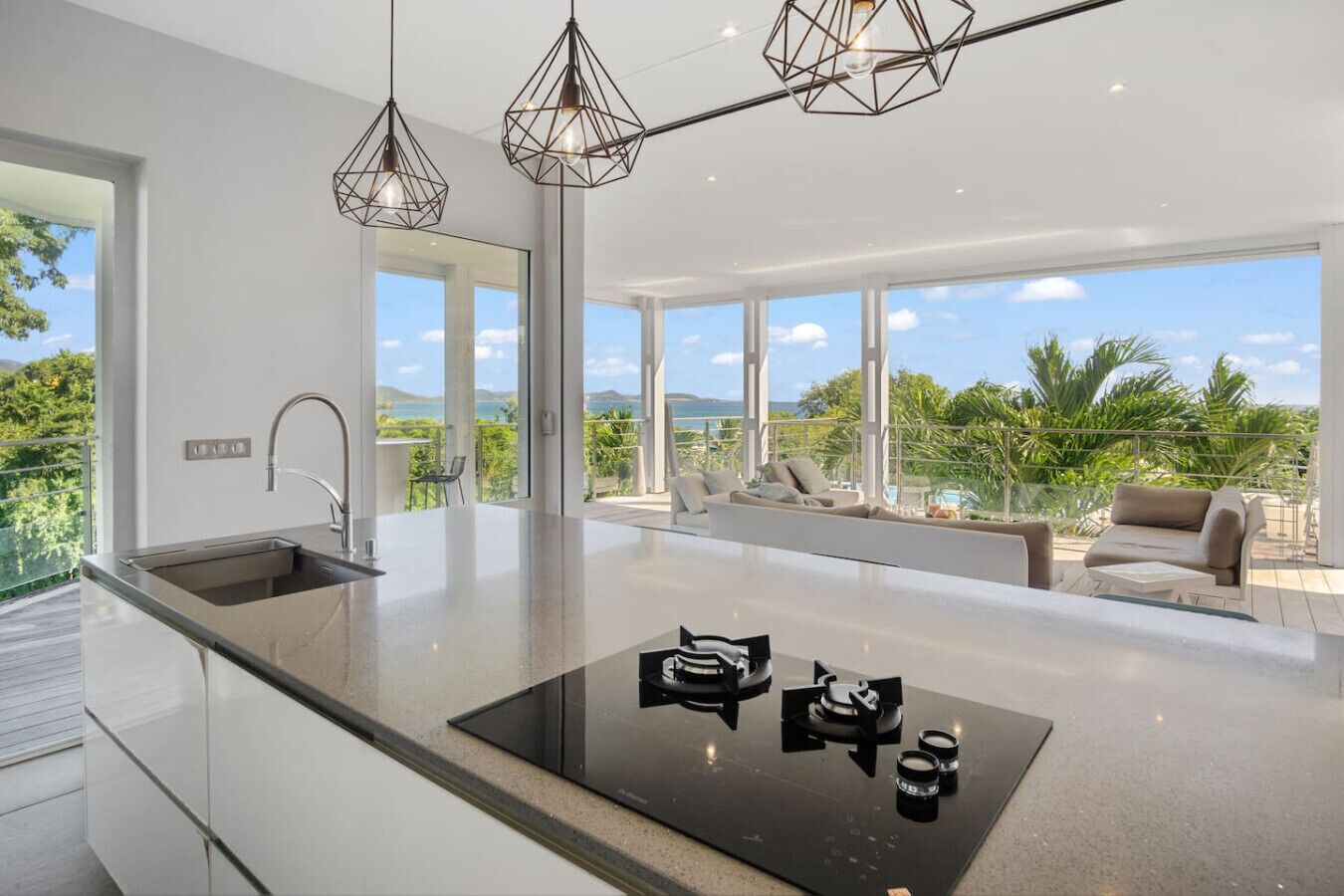 A modern kitchen with a central island, a built-in sink, and pendant lighting.