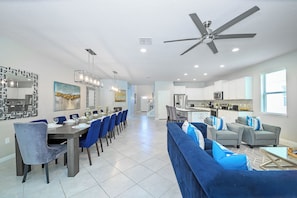 A modern kitchen with white cabinets, a microwave, and a stove. - Bengal Court Reserve (Kissimmee)