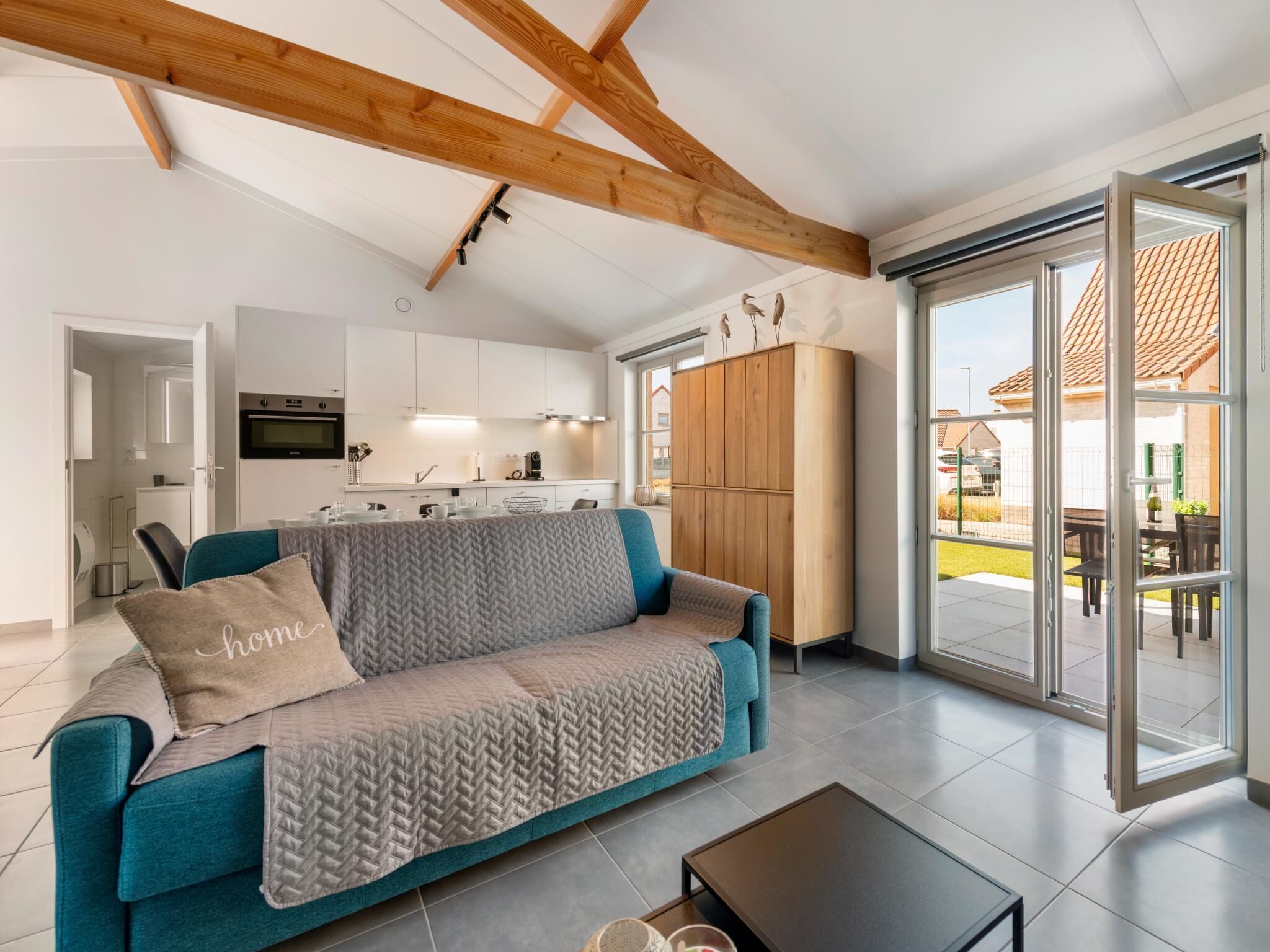 A modern living room with a sofa, a coffee table, and a view of the outside.