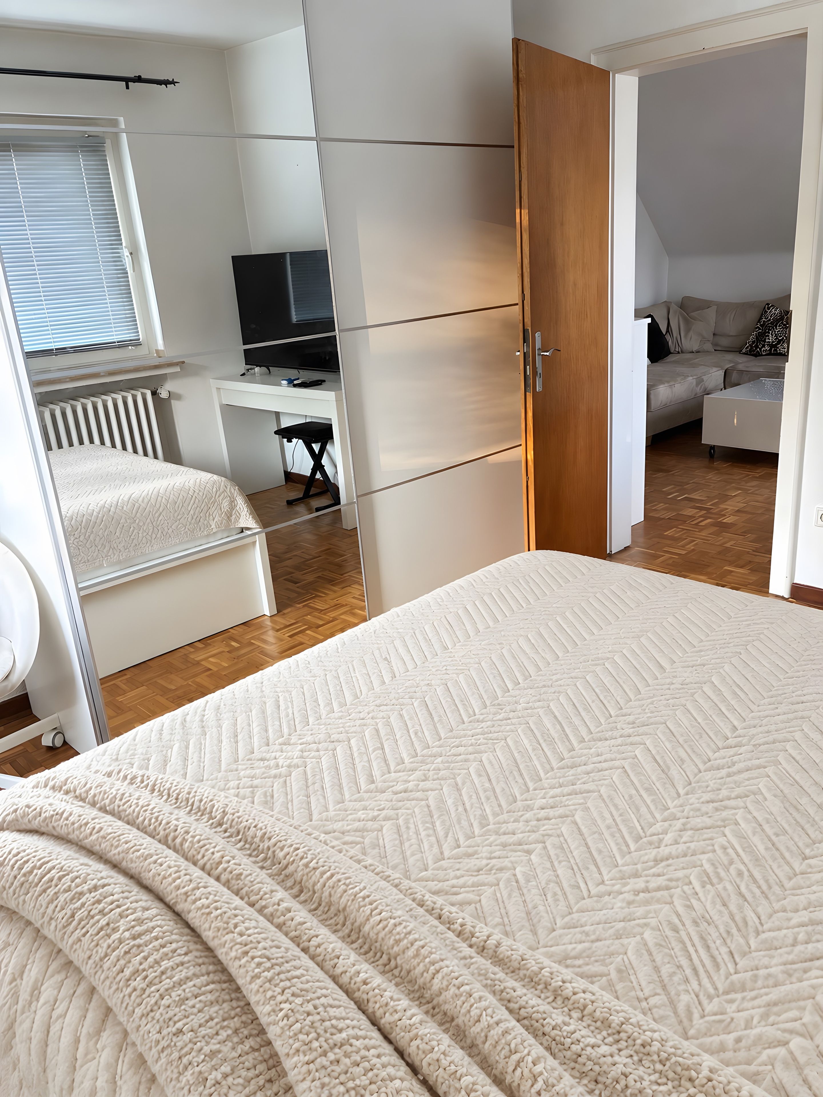 Ein Schlafzimmer mit einem Bett, einem Schreibtisch, einer Heizung und einem Fernseher.