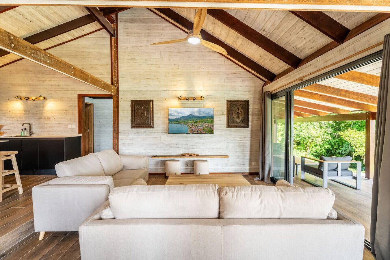 Ein modernes Interieur mit hoher Decke, einer Sofagarnitur, einem Esstisch und einem Gemälde.