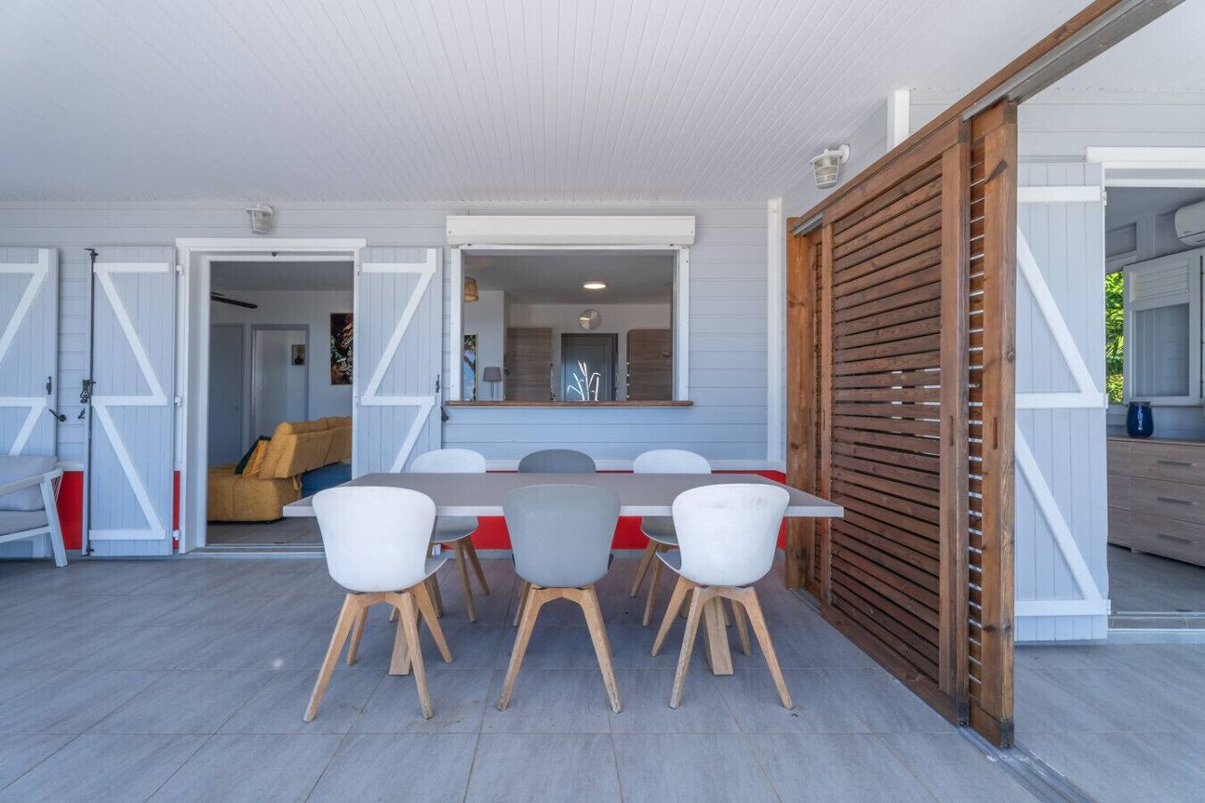 Un espace repas comprenant une table et des chaises, un canapé et une cloison en bois.