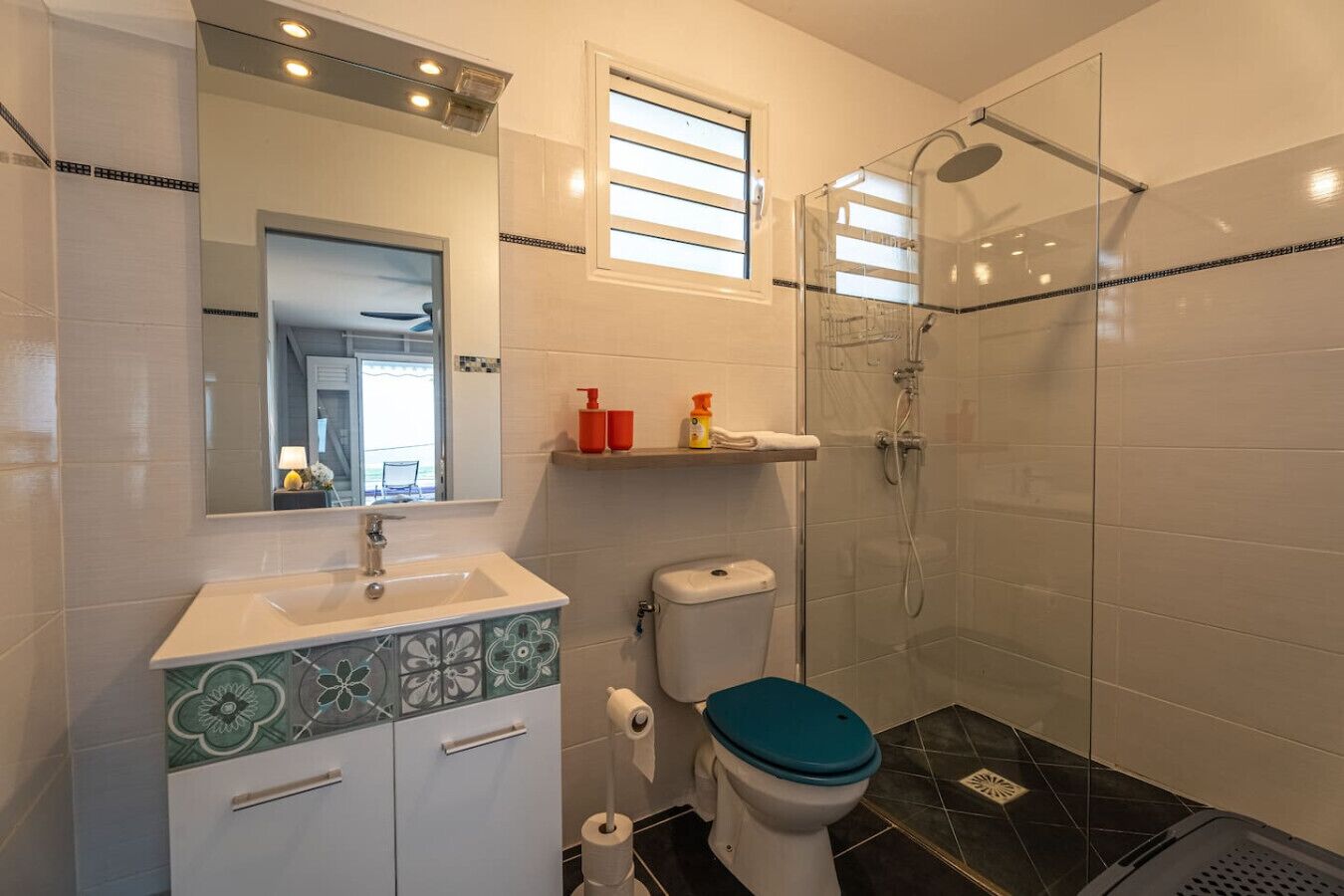 Une salle de bain avec des toilettes, un lavabo et une douche.
