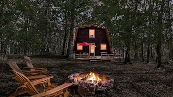 A cabin with a fire pit and outdoor seating.