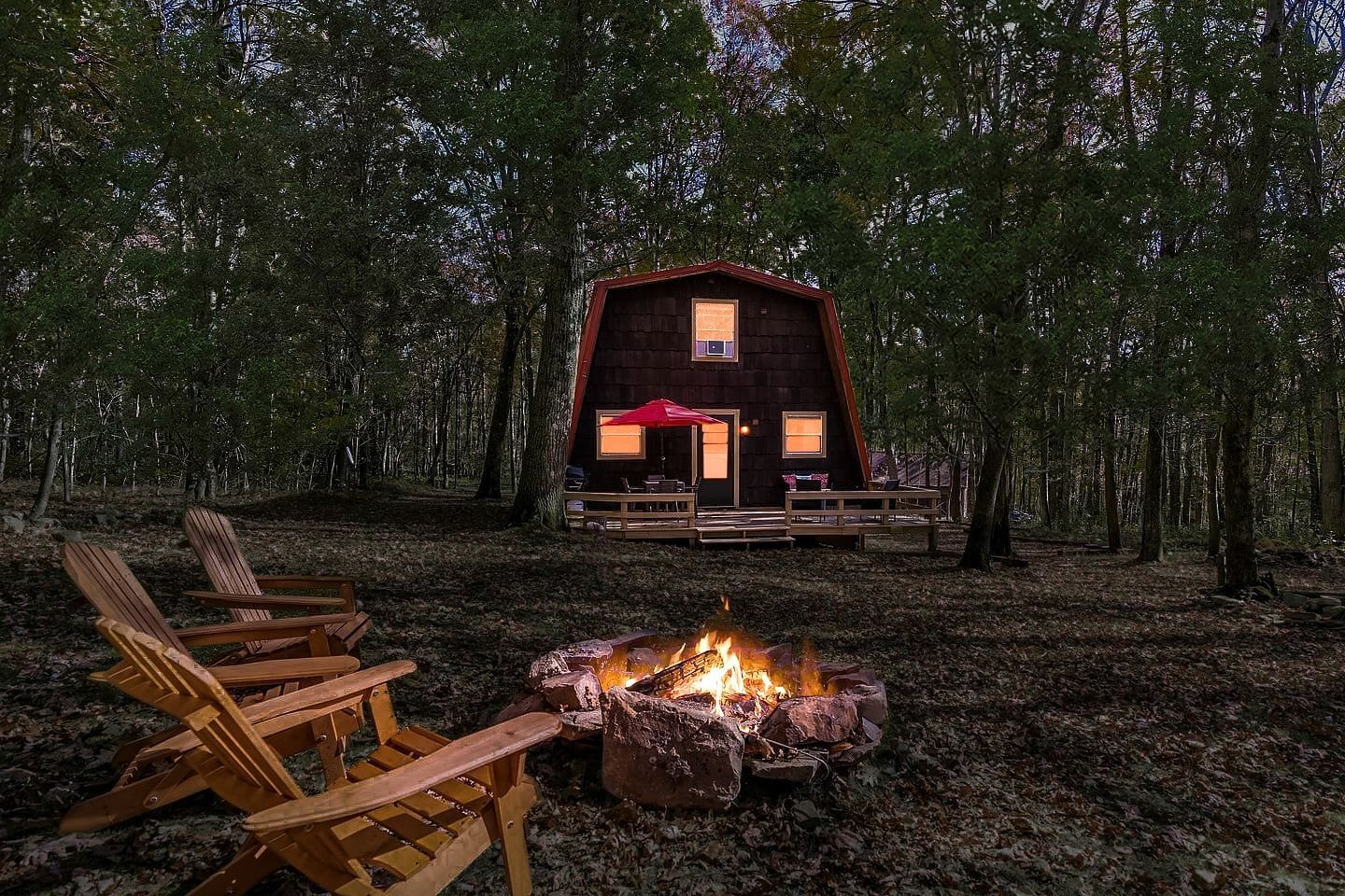 A cabin with a fire pit and outdoor seating.