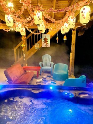 A hot tub area with seating and a staircase. - Awesome Wooden Cabin with Fire Pit in Great Cacapon, West Virginia (Great Cacapon)