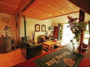 A cozy living room with a fireplace, a television, and a coffee table. - Charming farm with sauna and hot tub (Balkbrug)