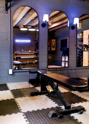 A gym with a mirrored wall, exercise equipment, and a checkered floor. - Enchanting Creekside Mountain Cabin Retreat with Luxury Amenities in the Heart of Scenic Blue Ridge, Georgia (Blue Ridge)