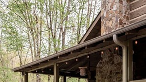 Eine rustikale Holzhütte mit Natursteinfassade, einer Holzdiele und einem Kamin aus Stein.