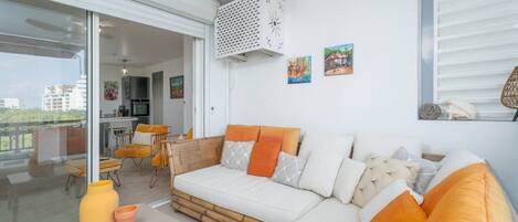 A modern living room with a sofa, chairs, and a dining area.