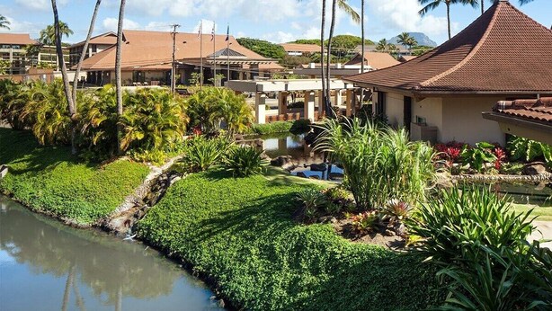 Ein Resort mit Pool, Palmen und einem kleinen Wasserspiel.