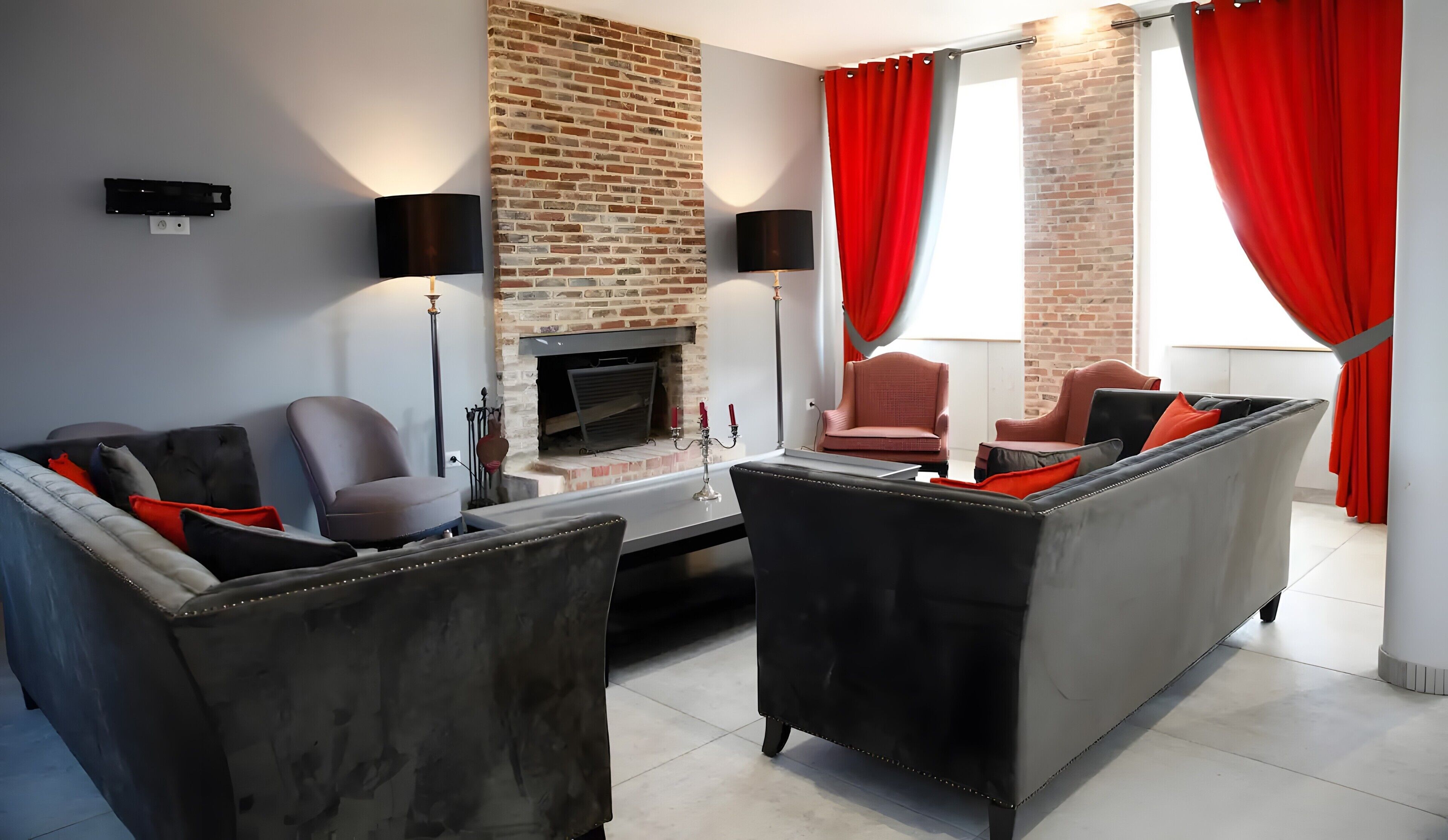 A modern living room with a brick fireplace, red curtains, and contemporary furniture.