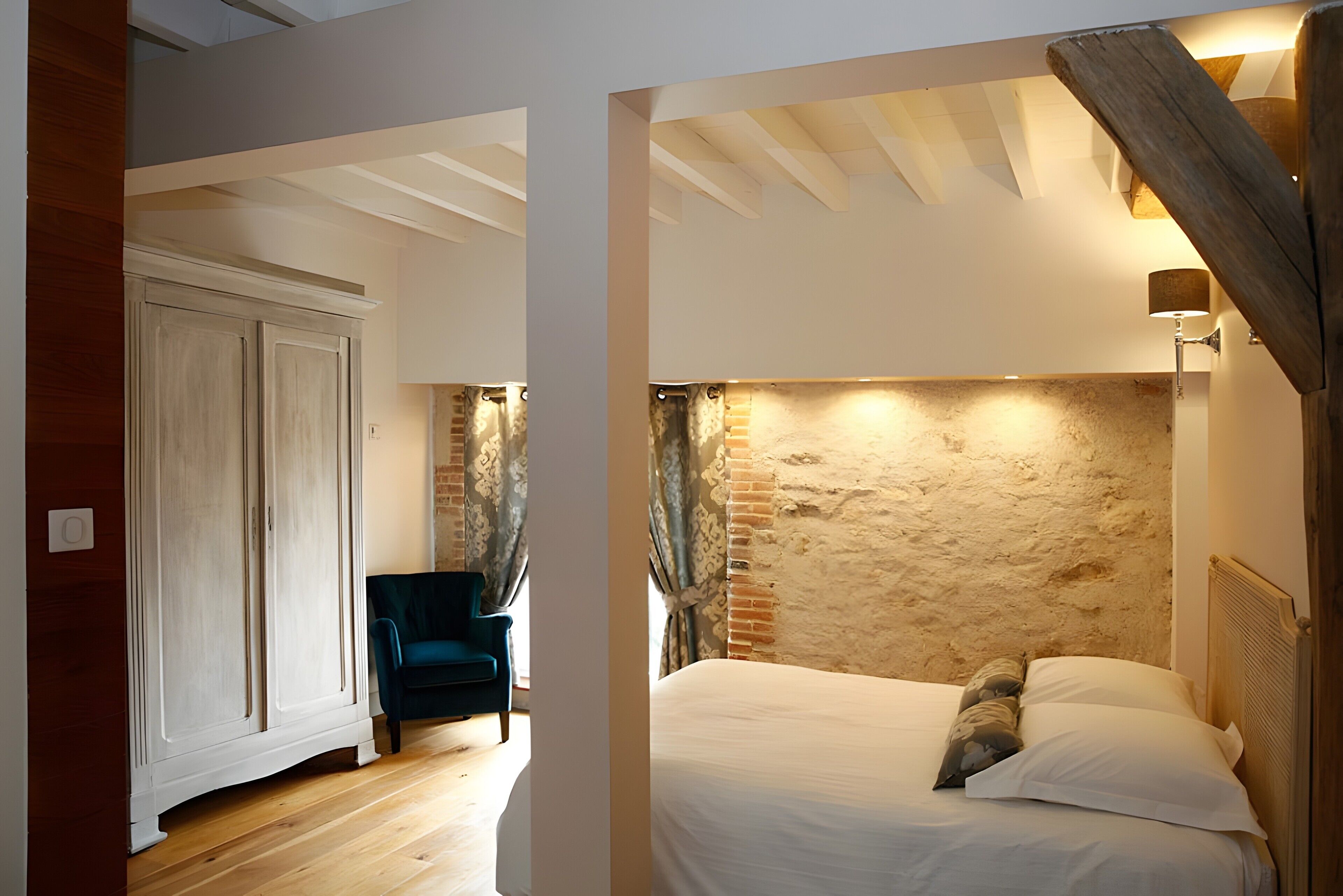 Een kamer met een bed, een stoel en een houten plafond.