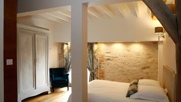 Een kamer met een bed, een stoel en een houten plafond.