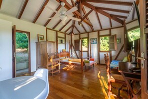 Ein geräumiger Raum mit Holzbalkendecke, einem Bett, einem Schreibtisch und einem Stuhl.