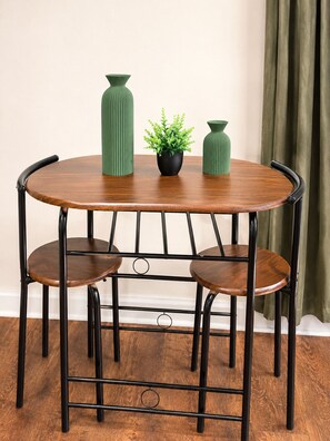 A round wooden table with three chairs, each with a curved backrest. - Cozy 1BR - Sleeps 4 - Walk to Downtown & Free Parking (Dallas)