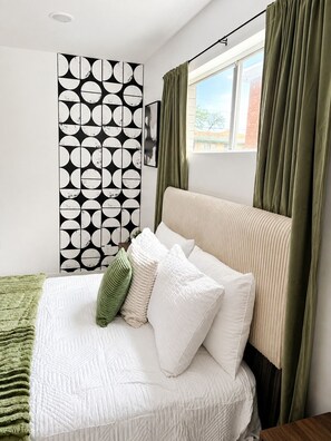 A bedroom with a bed, a patterned wall, and a window with curtains. - Cozy 1BR - Sleeps 4 - Walk to Downtown & Free Parking (Dallas)