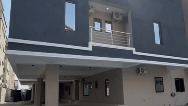 A modern two-story building with a flat roof, large windows, and a covered parking area. - Premium 1-Bedroom in Victoria Island with Pool, Fast Wi-Fi & 24/7 Power (Lagos)