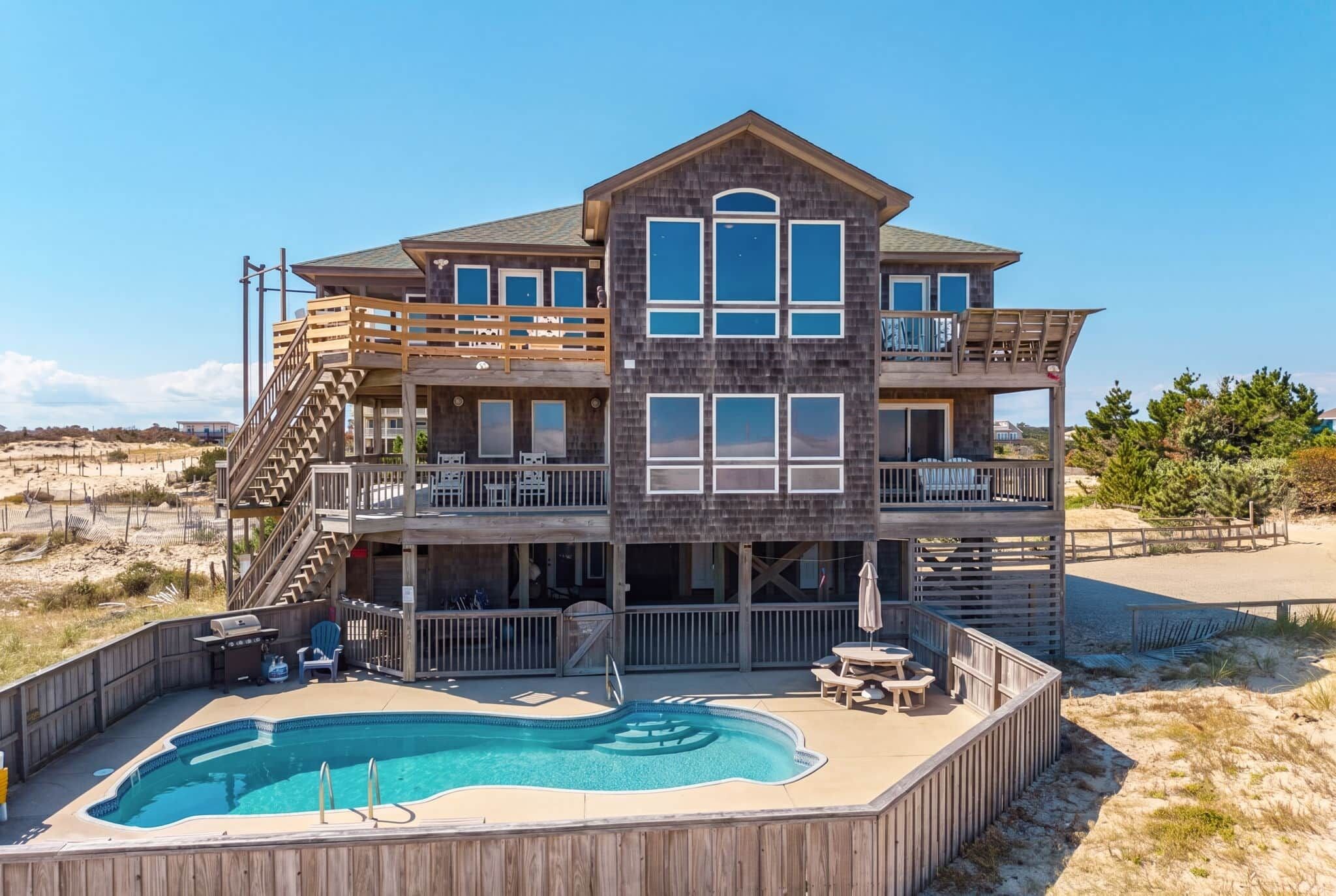 A two-story building with a pool and outdoor seating.