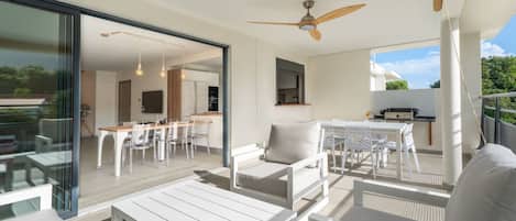 A modern outdoor living area with a dining table, chairs, and a sofa.