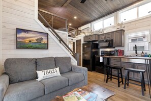 A modern kitchen with a built-in stove, microwave, and refrigerator. - Refined Tiny Home Getaway with Resort Amenities Near Fredericksburg, TX (Fredericksburg)