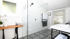 A modern bathroom with a shower, a sink, and a toilet.