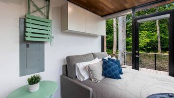 A modern bedroom with a bed, a small table, and a bench.