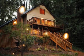 Une cabane à deux étages dotée d’un balcon et d’un escalier menant à l’étage supérieur.