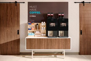 Eine Kaffeestation mit zwei Espressomaschinen, einem Kaffeeautomaten sowie verschiedenen Kaffeetassen und -behältern.
