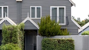 A residential building with a grey exterior, white window frames, a black door, and a small balcony. - Tranquil Vacation Rental with Amazing Lake Views and Hiking Trails in Daylesford, Victoria (Daylesford)